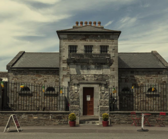 Tarbert Bridewell, with barred windows and red chairs outside, near the Flying Boat Museum.